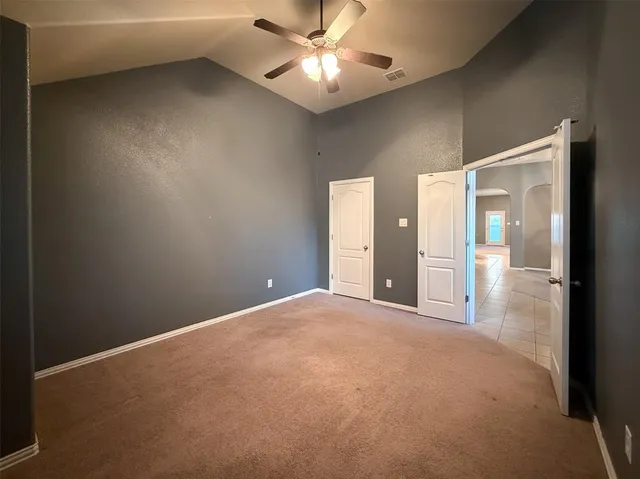 a view of a room with a ceiling fan and a window
