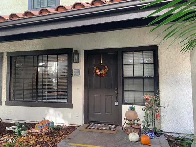 a living room with furniture and a refrigerator