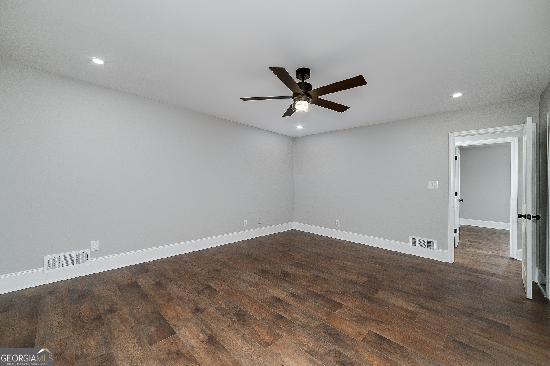 858 Pates Creek Road Stockbridge, GA 30281 - Photo 13 of 27 an empty room with wooden floor and a ceiling fan
