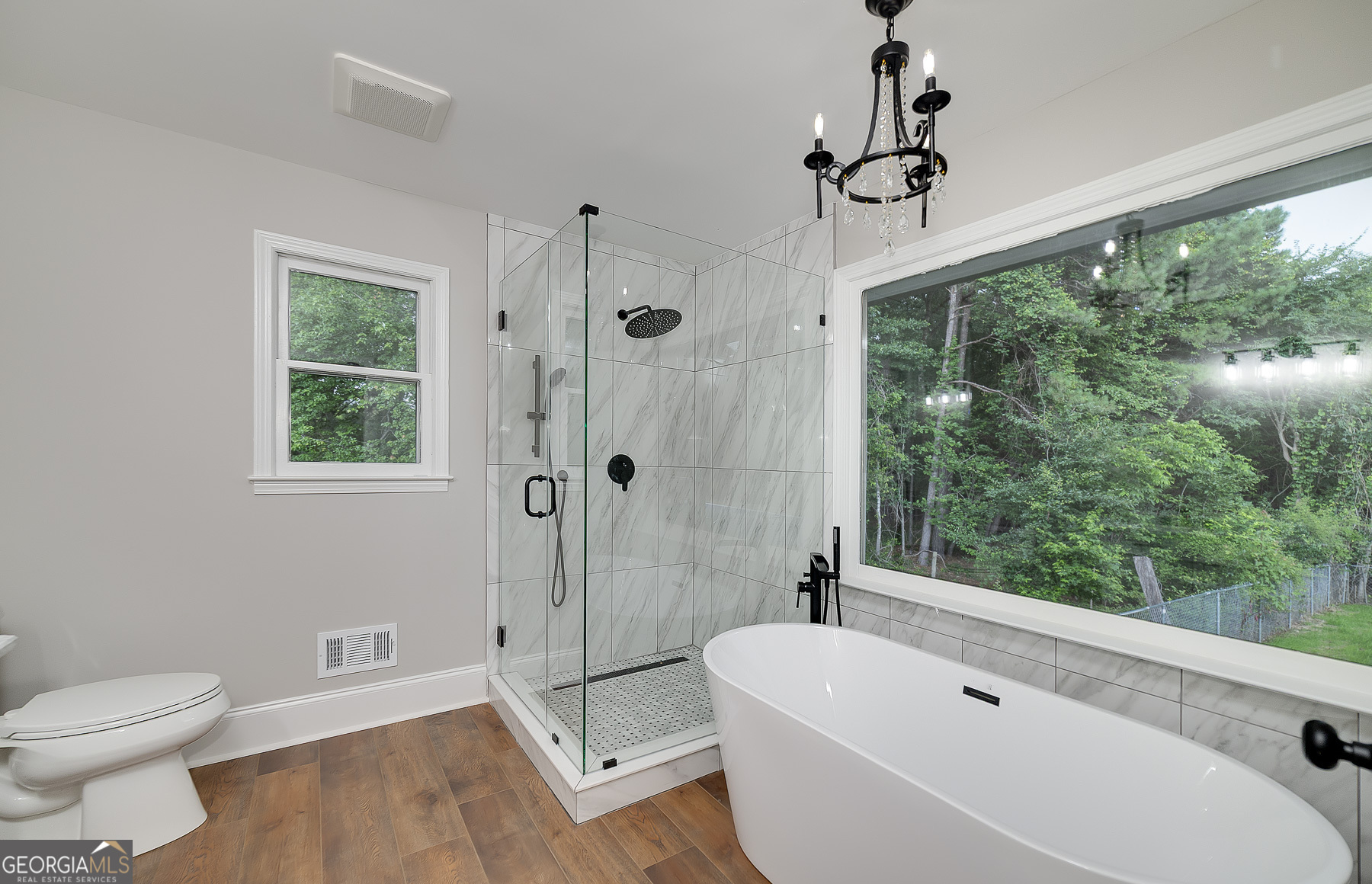 858 Pates Creek Road Stockbridge, GA 30281 - Photo 14 of 27 a bathroom with a sink a toilet a large mirror a bathtub and next to a window