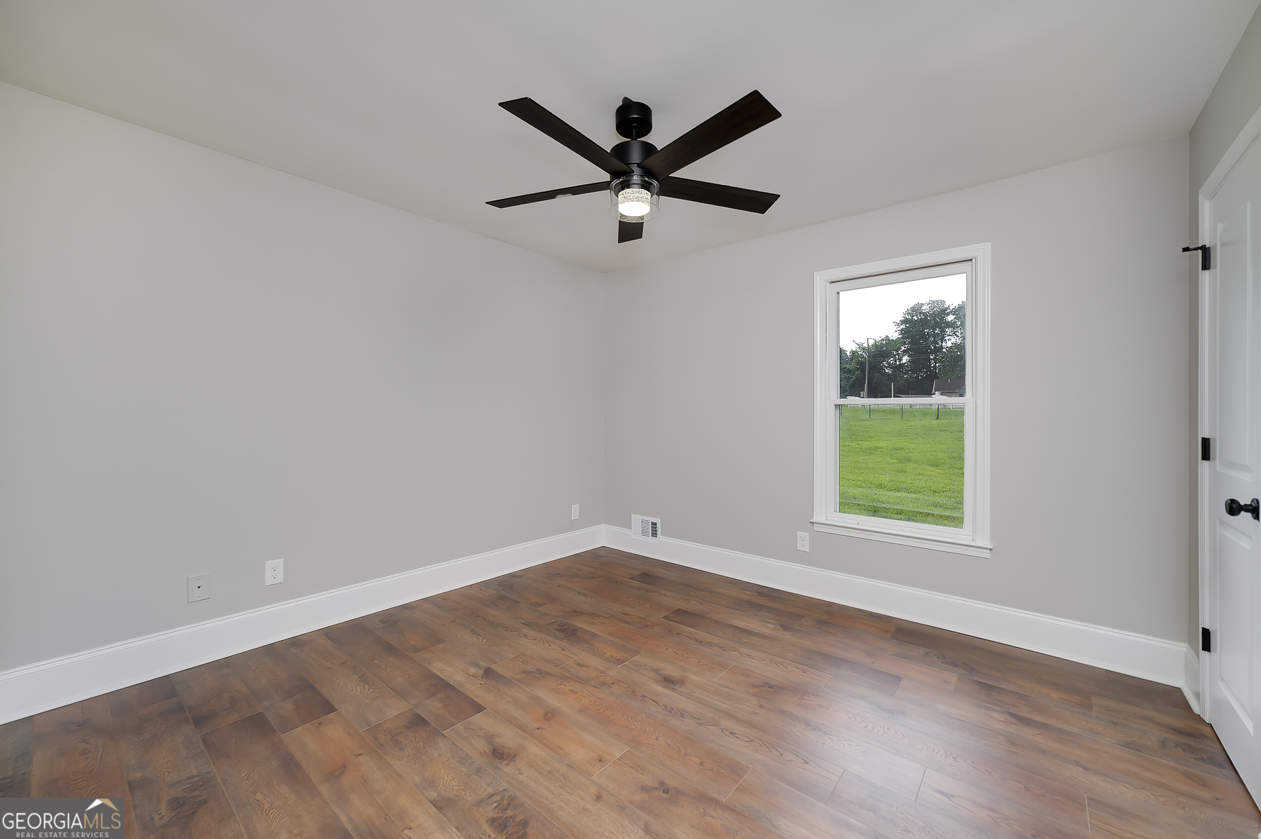 858 Pates Creek Road Stockbridge, GA 30281 - Photo 19 of 27 an empty room with wooden floor and windows