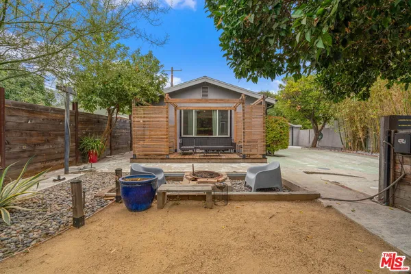 a view of a house with backyard and sitting area