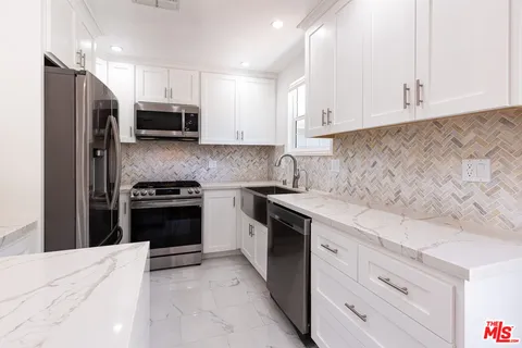 a kitchen with stainless steel appliances a stove microwave and refrigerator