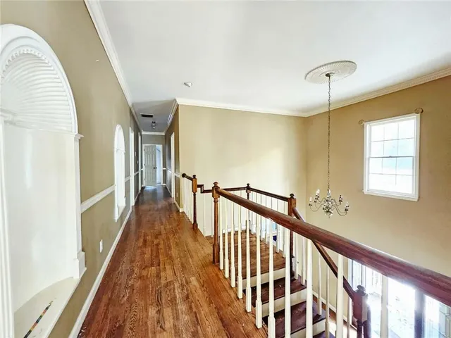 a view of a hallway with wooden floor and staircase