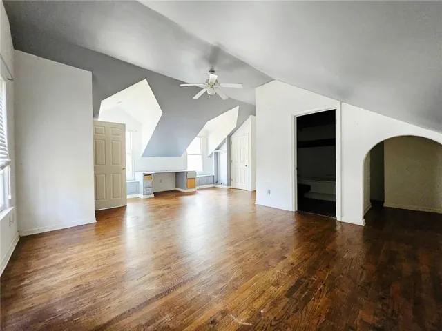 a view of empty room with wooden floor and fireplace