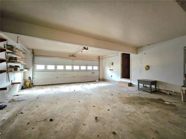 a view of a white house with large windows and a tree