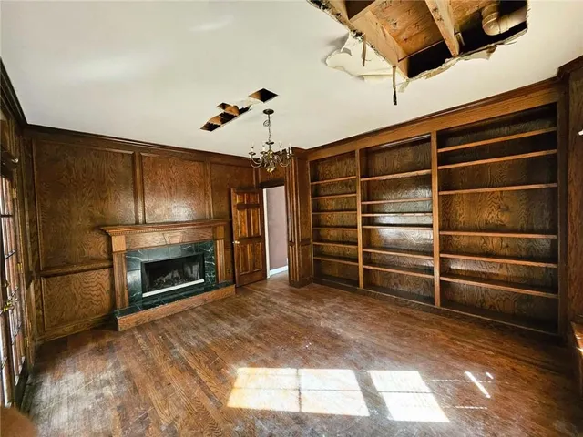a view of an empty room with a fireplace and a window