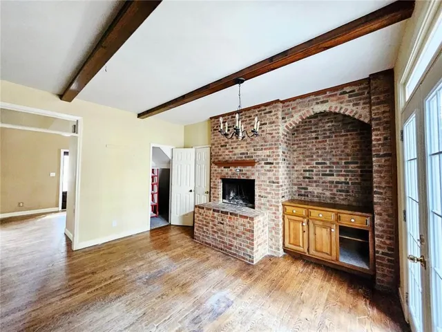 a view of empty room with wooden floor and fireplace