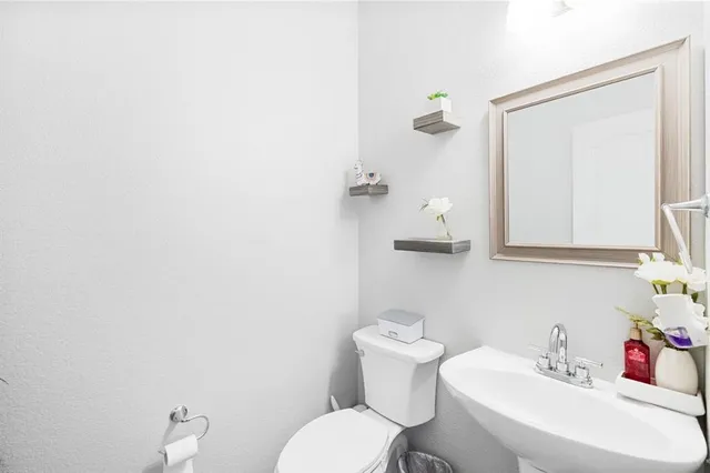a bathroom with a toilet a sink and mirror