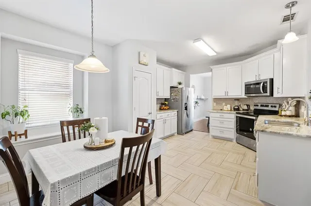 a kitchen with a table chairs microwave and cabinets