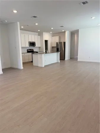 a kitchen with granite countertop a refrigerator a stove a sink a washer and dryer with wooden floor