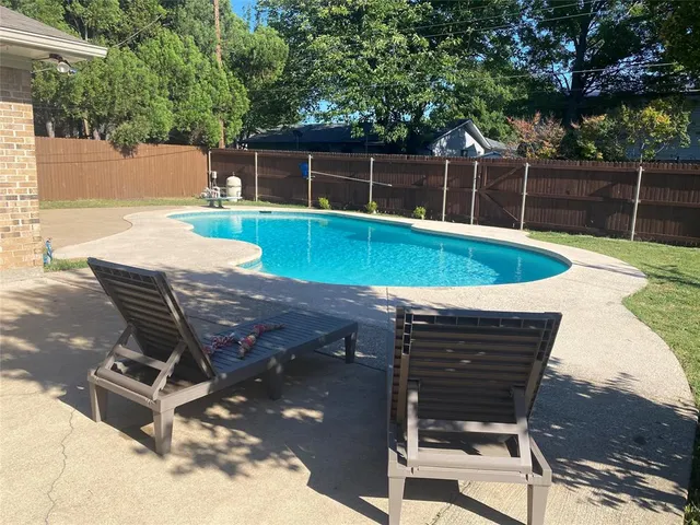 a view of a backyard with swimming pool