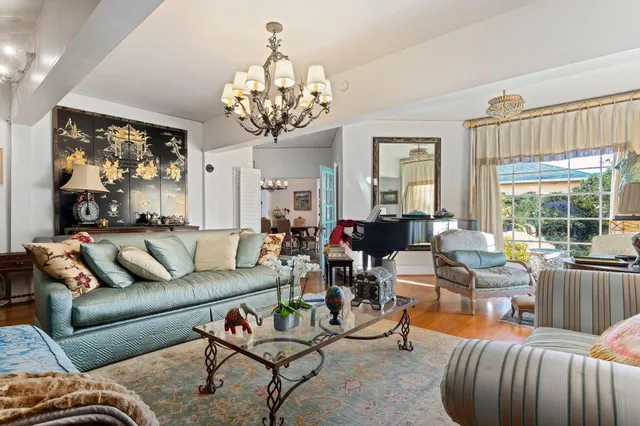 a living room with furniture chandelier and a large window