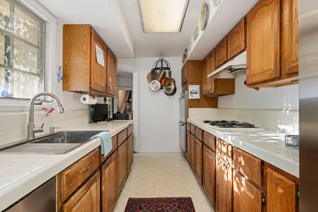 a kitchen with granite countertop a sink stove and cabinets