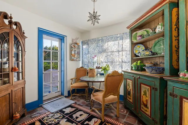a dining room with furniture a floor to ceiling window and wooden floor