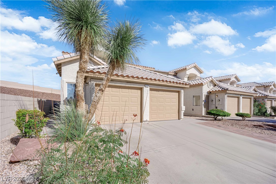 Mediterranean / spanish-style house with stucco siding, driveway, a garage, and a tiled​​‌​​​​‌​​‌‌​‌‌​​‌​​​​‌​​​‌‌​‌‌‌ roof