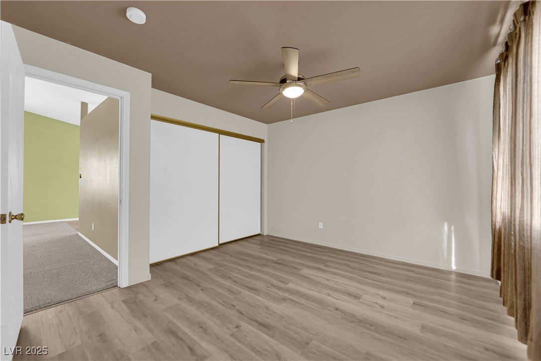 7572 Durham Hall Avenue, Unit 201 Las Vegas, NV 89130 - Photo 13 of 26 Unfurnished bedroom featuring light wood-type flooring, a closet, and a ceiling fan