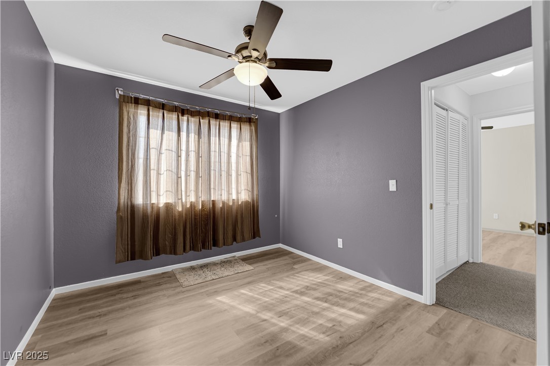 7572 Durham Hall Avenue, Unit 201 Las Vegas, NV 89130 - Photo 18 of 26 Spare room featuring light wood finished floors, a ceiling fan, and a textured wall