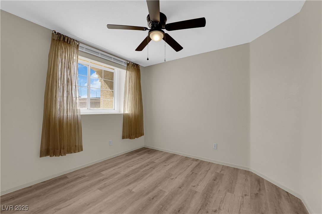 7572 Durham Hall Avenue, Unit 201 Las Vegas, NV 89130 - Photo 19 of 26 Empty room featuring light wood-style floors and a ceiling fan