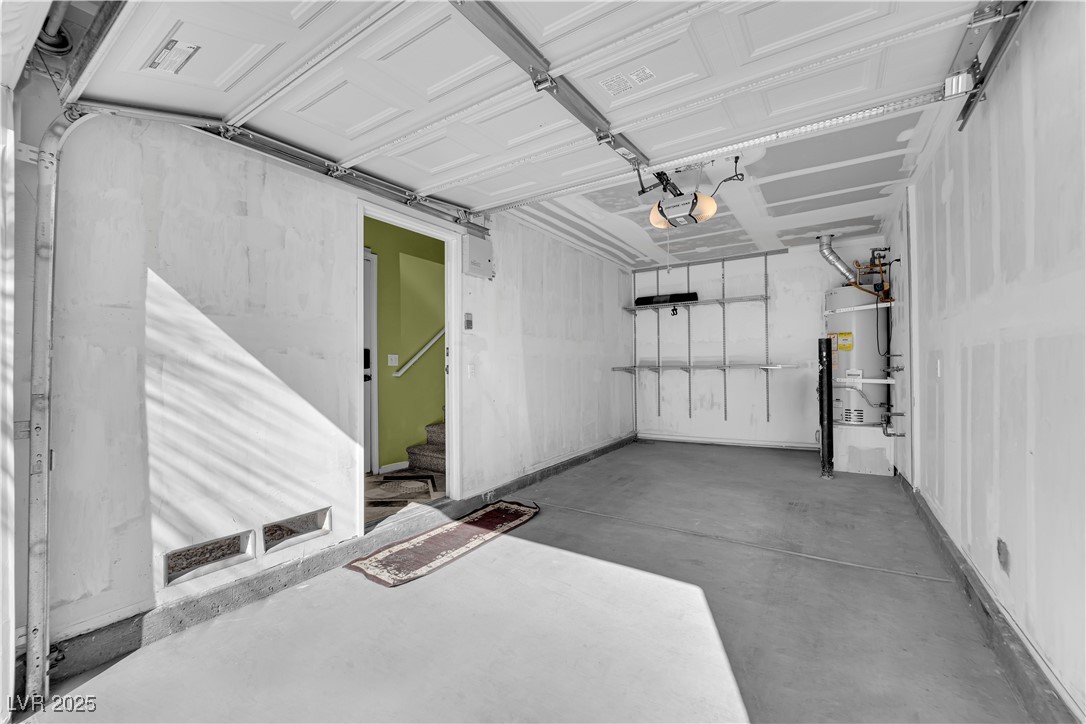 7572 Durham Hall Avenue, Unit 201 Las Vegas, NV 89130 - Photo 5 of 26 Garage featuring water heater and a garage door opener