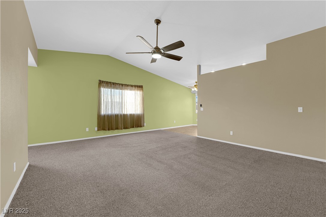 7572 Durham Hall Avenue, Unit 201 Las Vegas, NV 89130 - Photo 7 of 26 Empty room with vaulted ceiling, carpet floors, and a ceiling fan