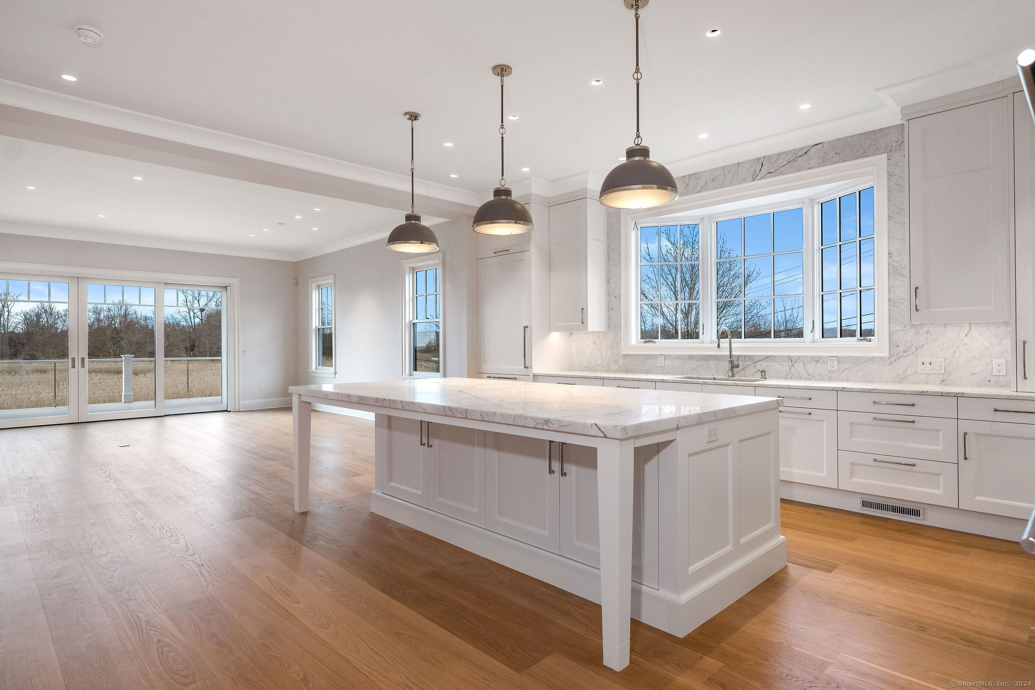 a large kitchen with kitchen island a large counter space wooden floor and a ceiling fan