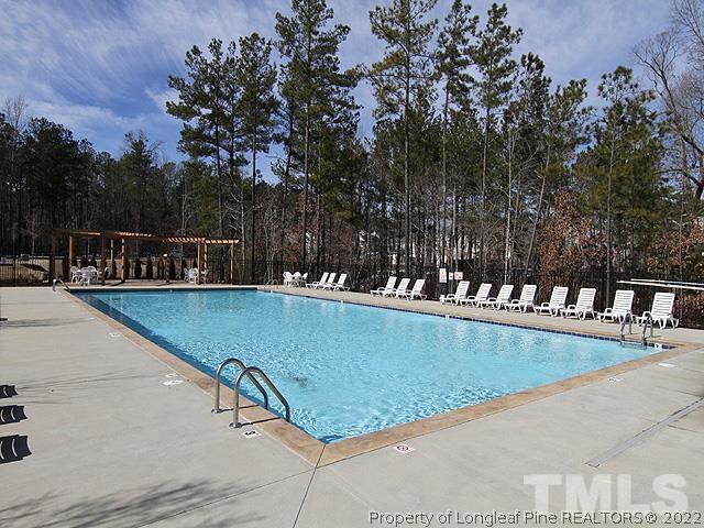 66 Intuition Circle Durham, NC 27705 - Photo 13 of 13 a view of a swimming pool with a bench and trees in the background