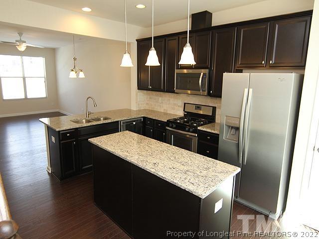 66 Intuition Circle Durham, NC 27705 - Photo 2 of 13 a kitchen with stainless steel appliances granite countertop a refrigerator a sink and wooden cabinets