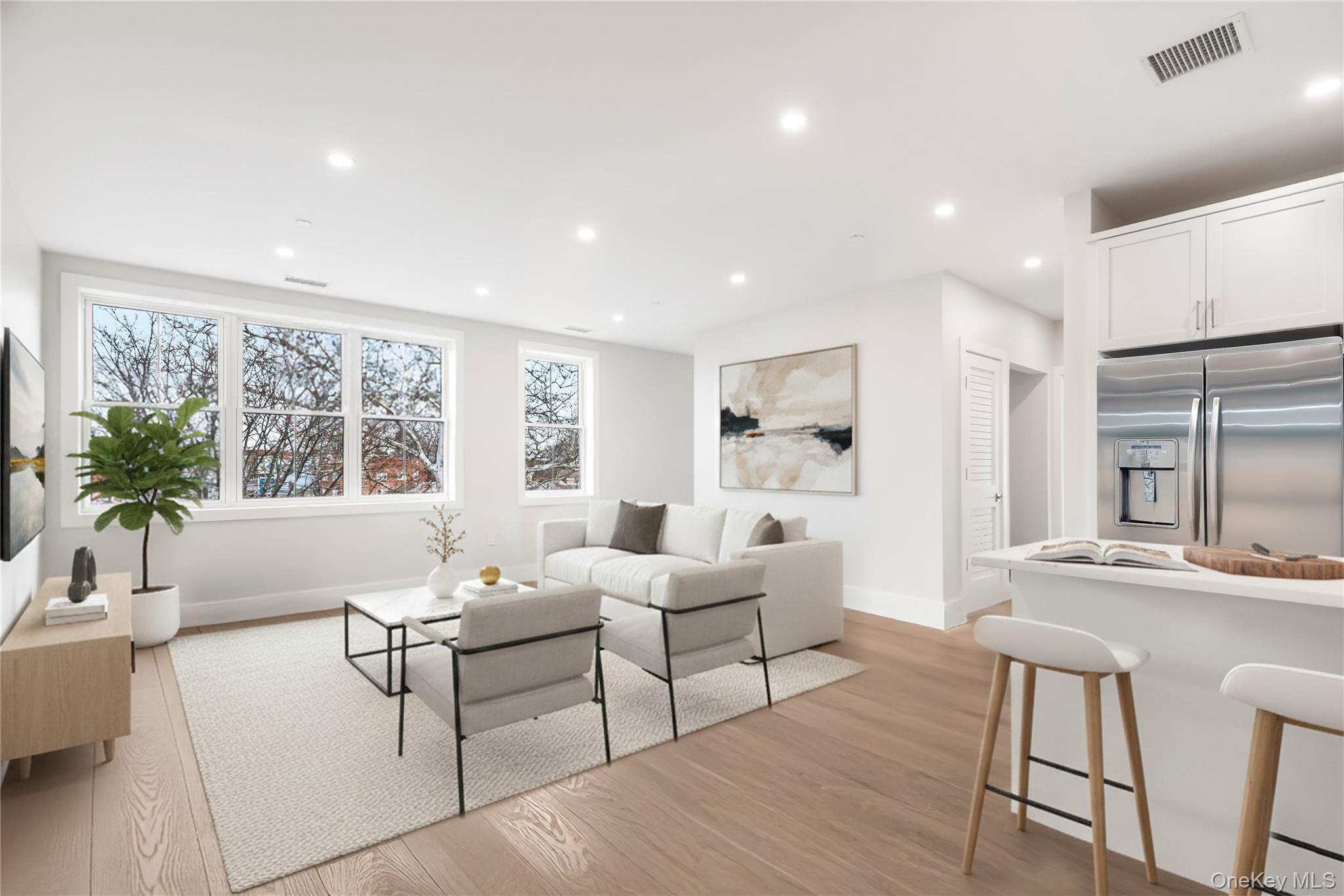 132 Halstead Avenue, Unit A Harrison, NY 10528 - Photo 4 of 19 Living room with light wood-type flooring and recessed lighting. Large windows make it bright and airy allowing for tons of natural light to flow through. Digitally staged.
