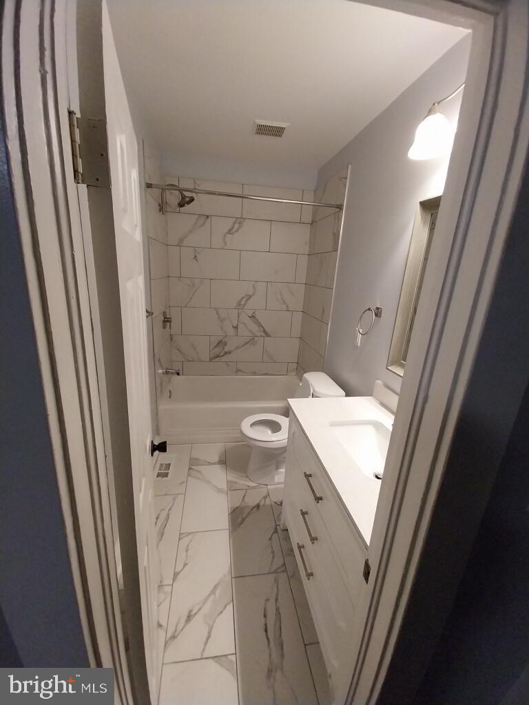7350 Montgomery Road Elkridge, MD 21075 - Photo 35 of 44 a bathroom with a granite countertop sink toilet and shower