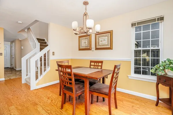 a view of a dining room with furniture a chandelier and wooden floor