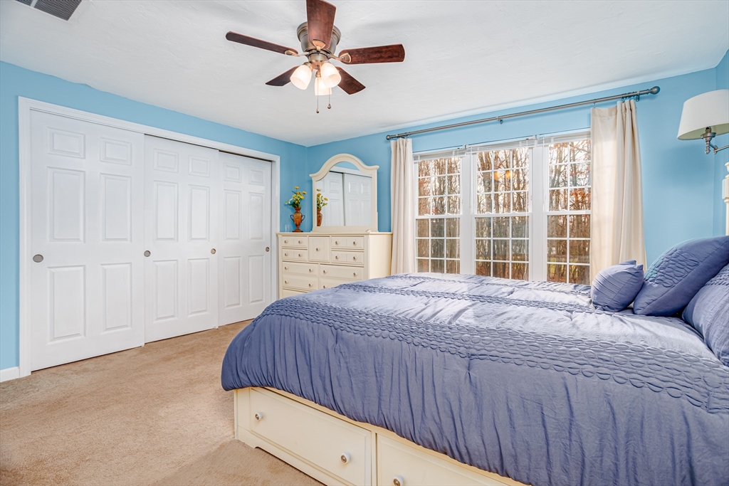 303 Ridgefield Circle, Unit C Clinton, MA 01510 - Photo 15 of 31 a bedroom with a large bed window and a chandelier