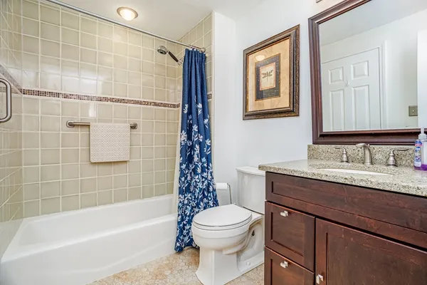 a bathroom with a granite countertop sink toilet and shower