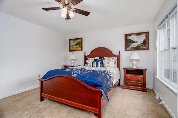 a bedroom with a bed and a lamp on the dresser