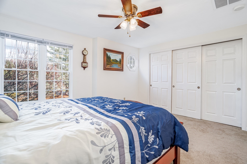 303 Ridgefield Circle, Unit C Clinton, MA 01510 - Photo 21 of 31 a bedroom with a large bed and a window