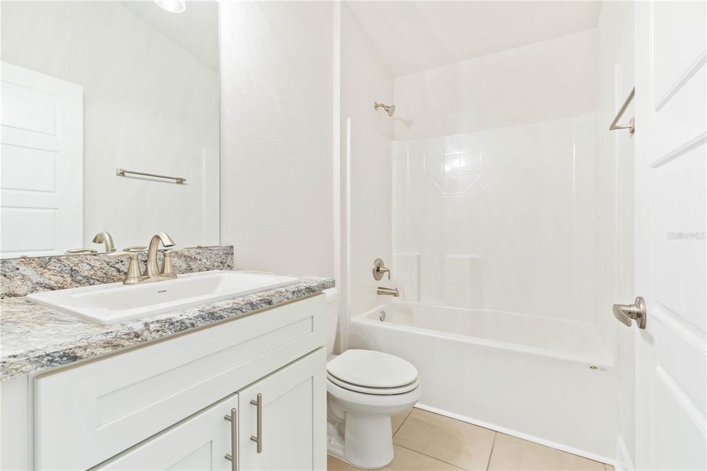 90 Rivertown Road Palm Coast, FL 32137 - Photo 49 of 60 a bathroom with a granite countertop sink toilet and shower