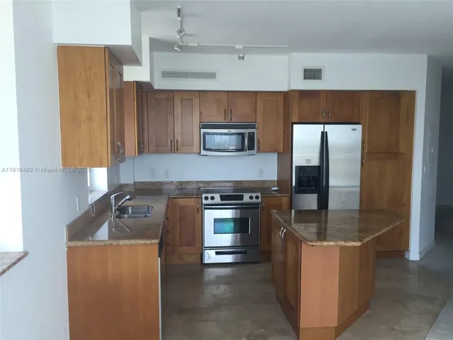 a kitchen with stainless steel appliances granite countertop a stove and a refrigerator