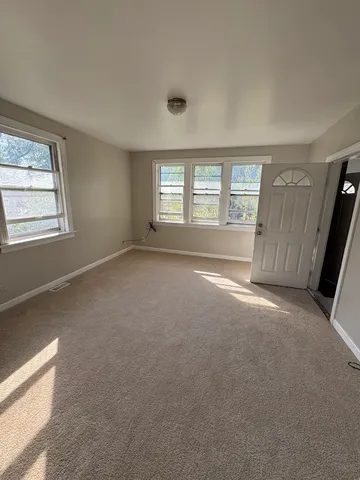 a view of an empty room with window and fireplace