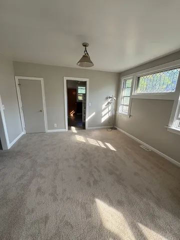 an empty room with windows and fan