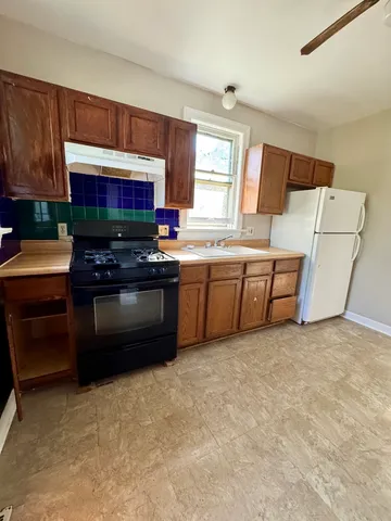 a kitchen with sink refrigerator and window
