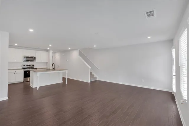a view of kitchen with kitchen island wooden floor center island and stainless steel appliances