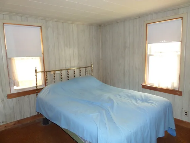 a bed sitting in a bedroom next to a window