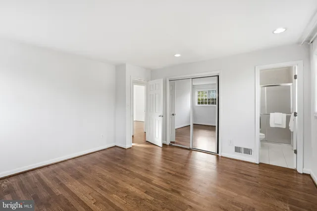 an empty room with wooden floor & bathroom