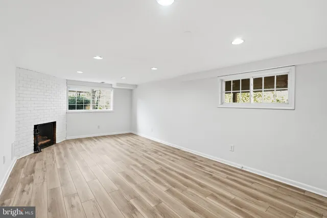 a view of empty room with wooden floor and fireplace