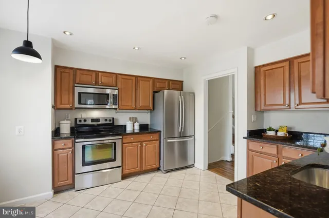 a kitchen with stainless steel appliances granite countertop a stove a sink and a refrigerator