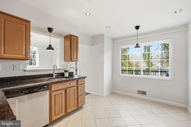 a kitchen with granite countertop a sink stove and cabinets