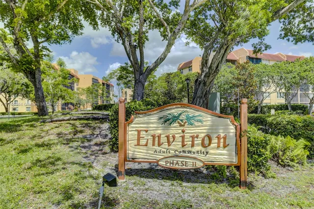 a view of a street sign under a large tree