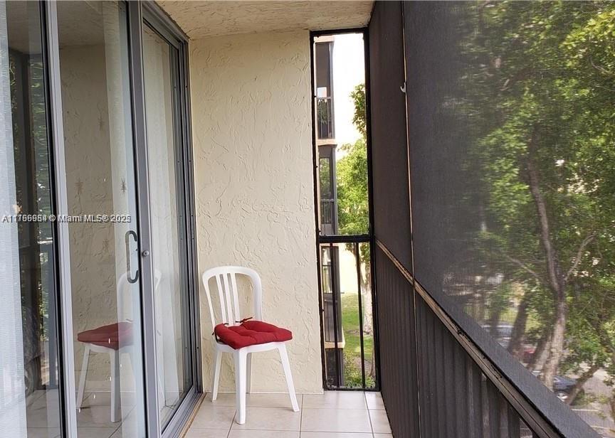 3821 Environ Boulevard, Unit 406 Lauderhill, FL 33319 - Photo 16 of 23 a balcony with wooden floor and outdoor seating