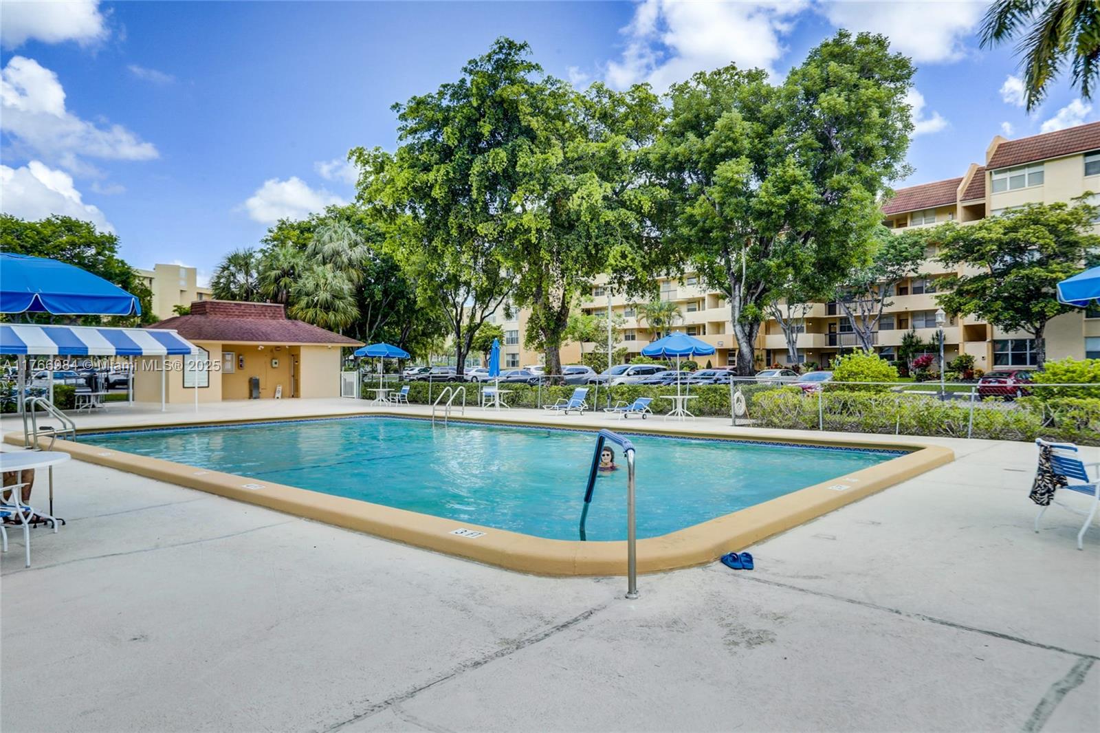 3821 Environ Boulevard, Unit 406 Lauderhill, FL 33319 - Photo 19 of 23 a view of a swimming pool with a bench and some trees