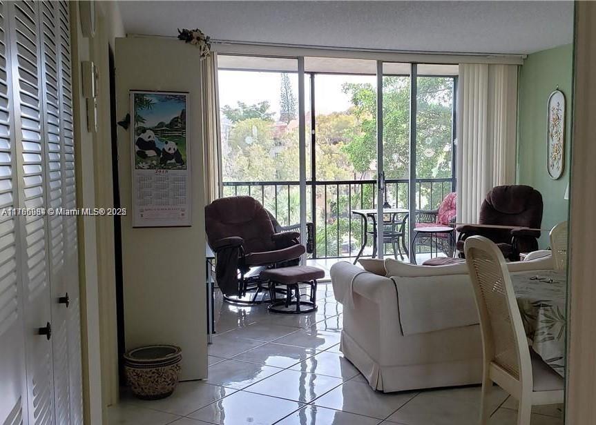 3821 Environ Boulevard, Unit 406 Lauderhill, FL 33319 - Photo 9 of 23 a living room with furniture and a floor to ceiling window